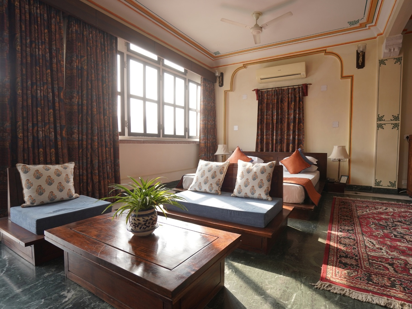 Courtyard Room — sitting area with sofa, cushions and wooden coffee table