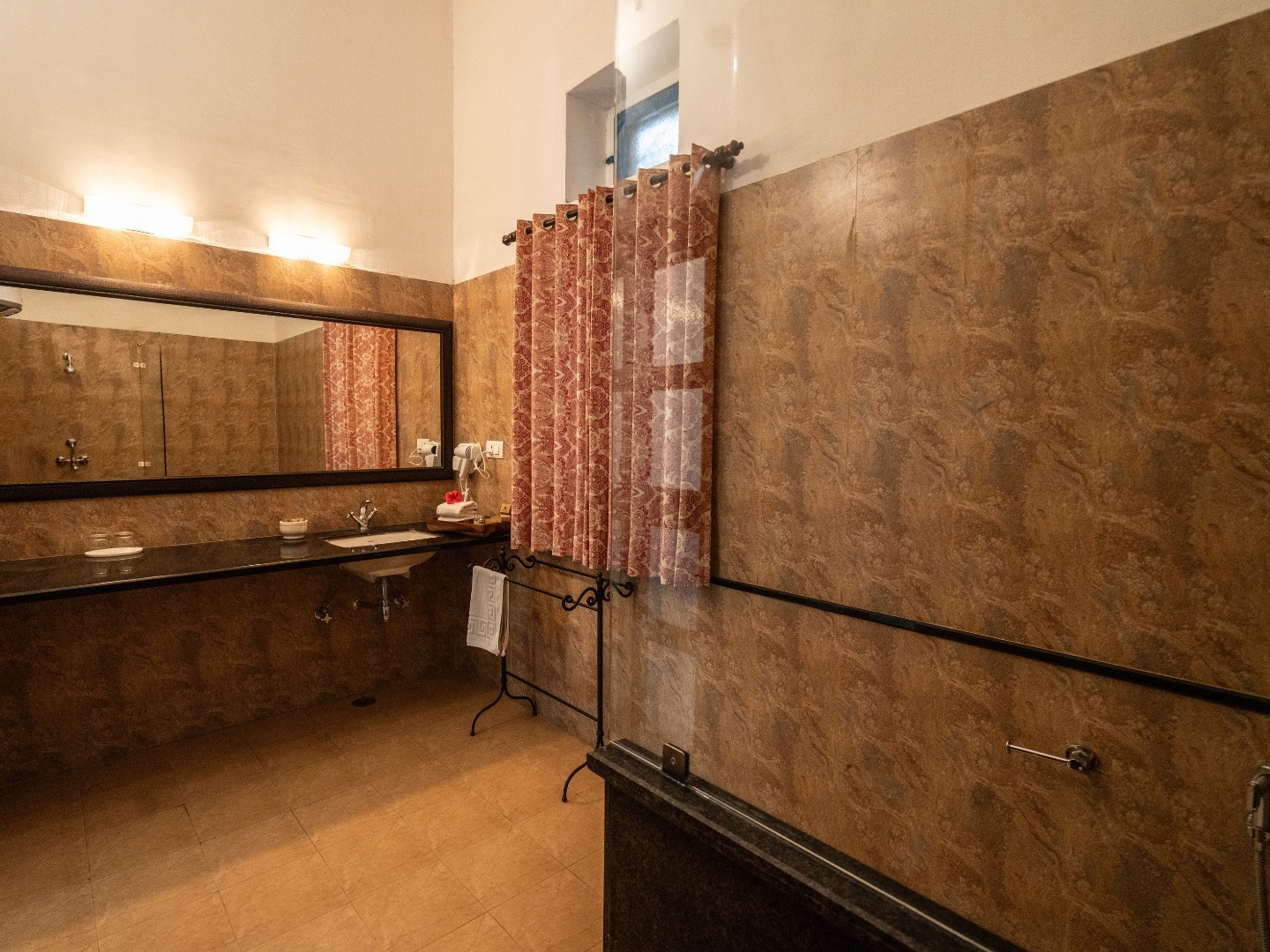 Heritage Deluxe — dressing area with long mirror and brown stone tiles