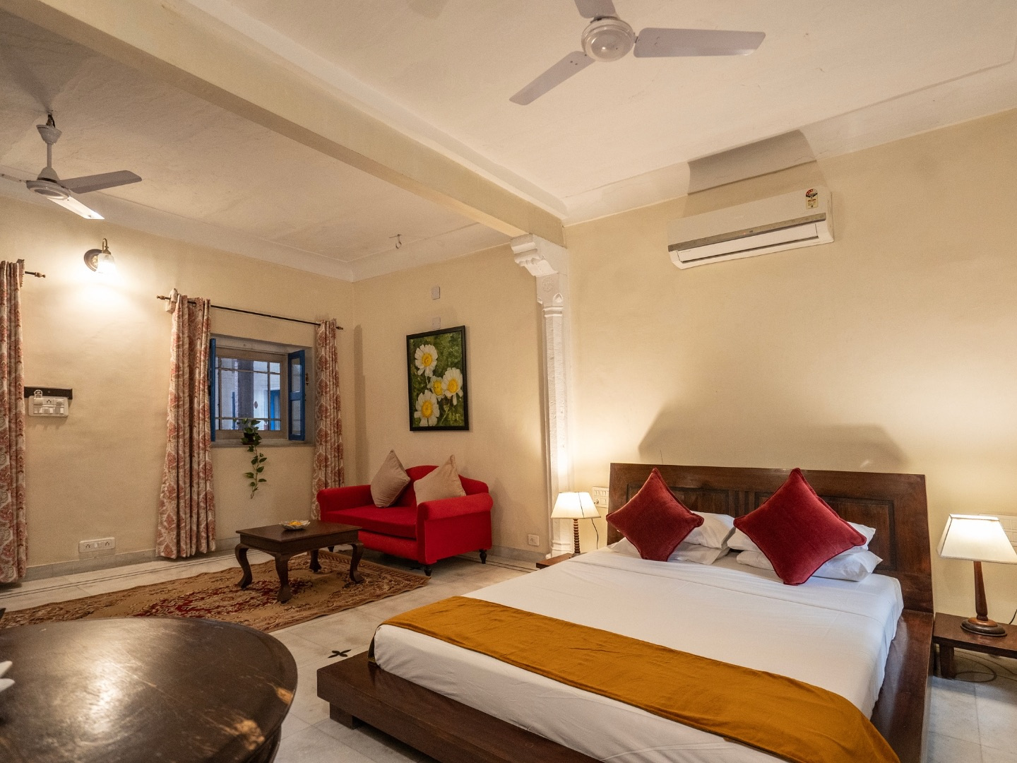 Heritage Deluxe — king bed with red cushions and a red sofa