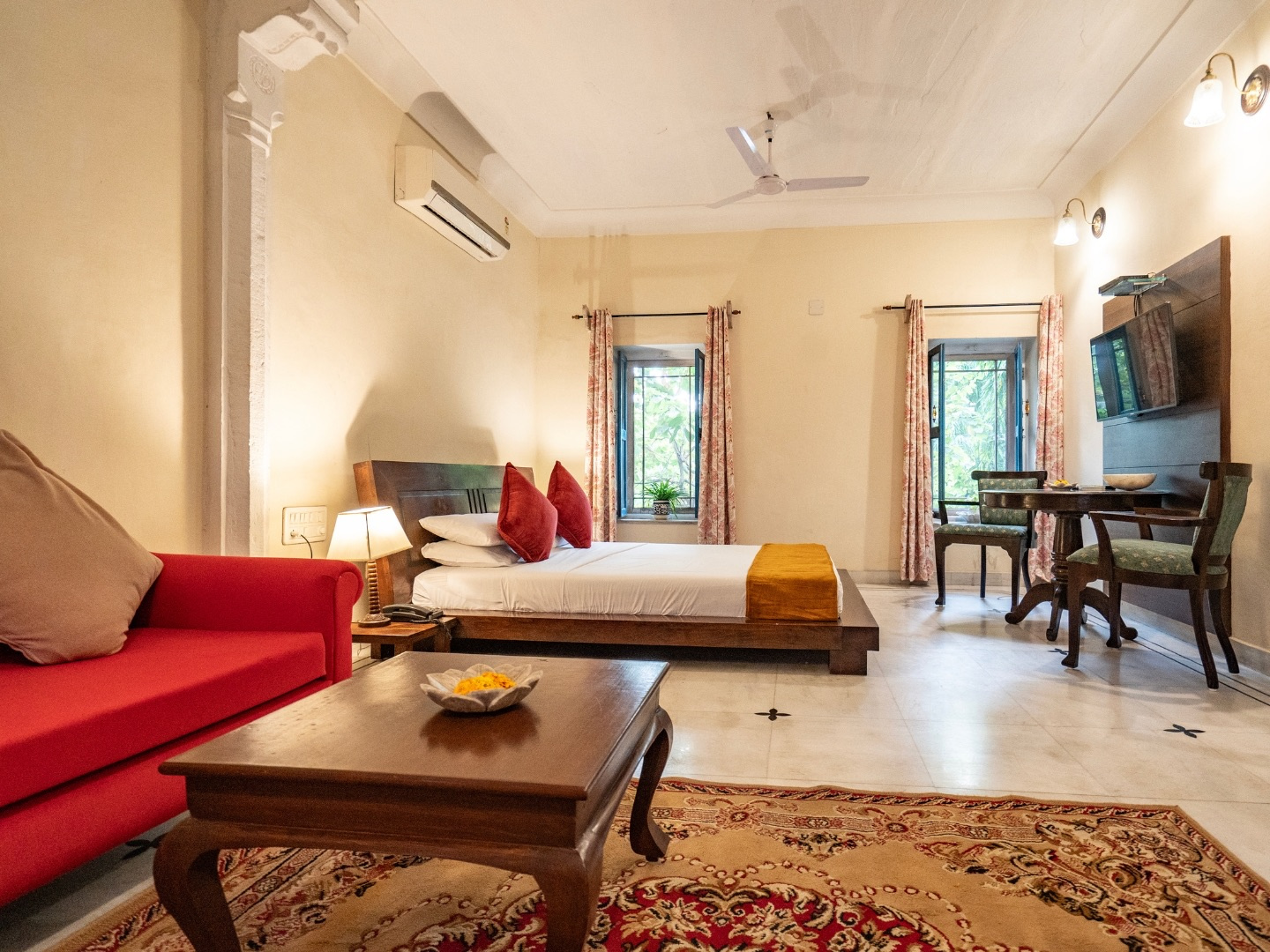 Heritage Deluxe — red sofa and wooden coffee table facing the bed