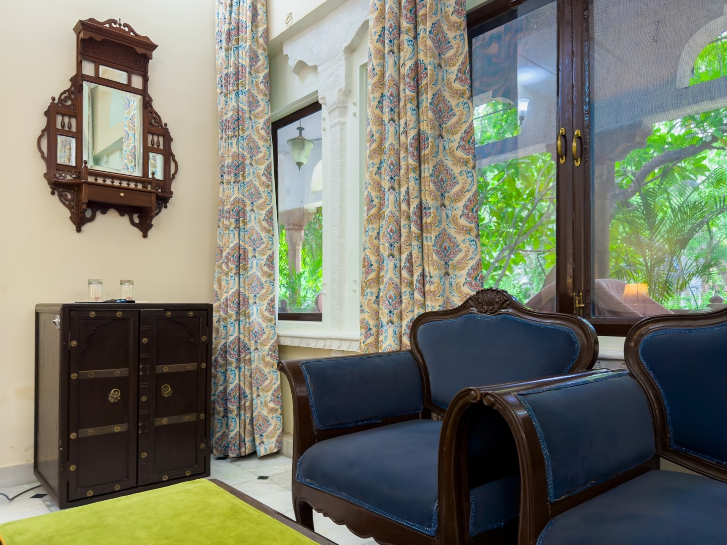 Heritage Standard — carved mirror, blue armchairs and garden view window